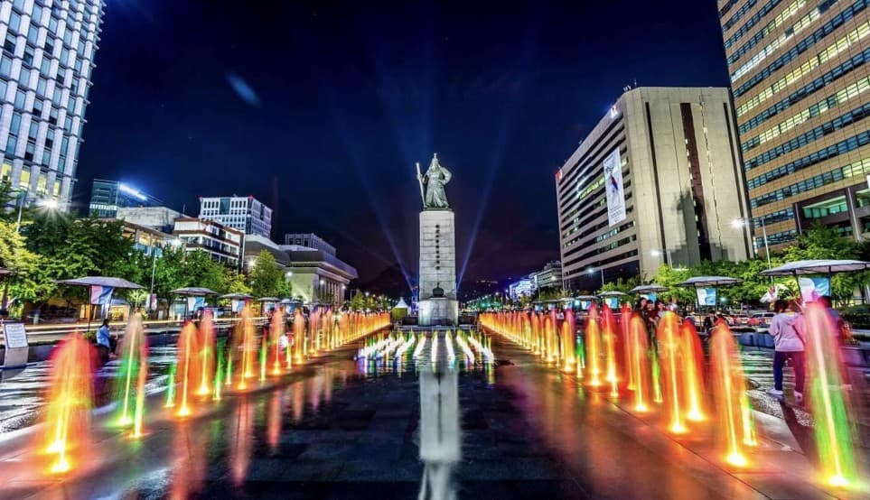 Illuminated fountains around the Admiral Yi Sun-sin statue at Gwanghwamun Square at night