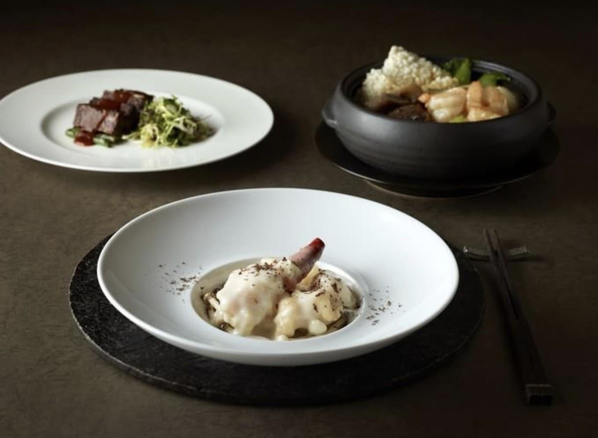 Elegant dark-toned Cantonese fine dining plates at Palsun, including a black clay pot and a plated course