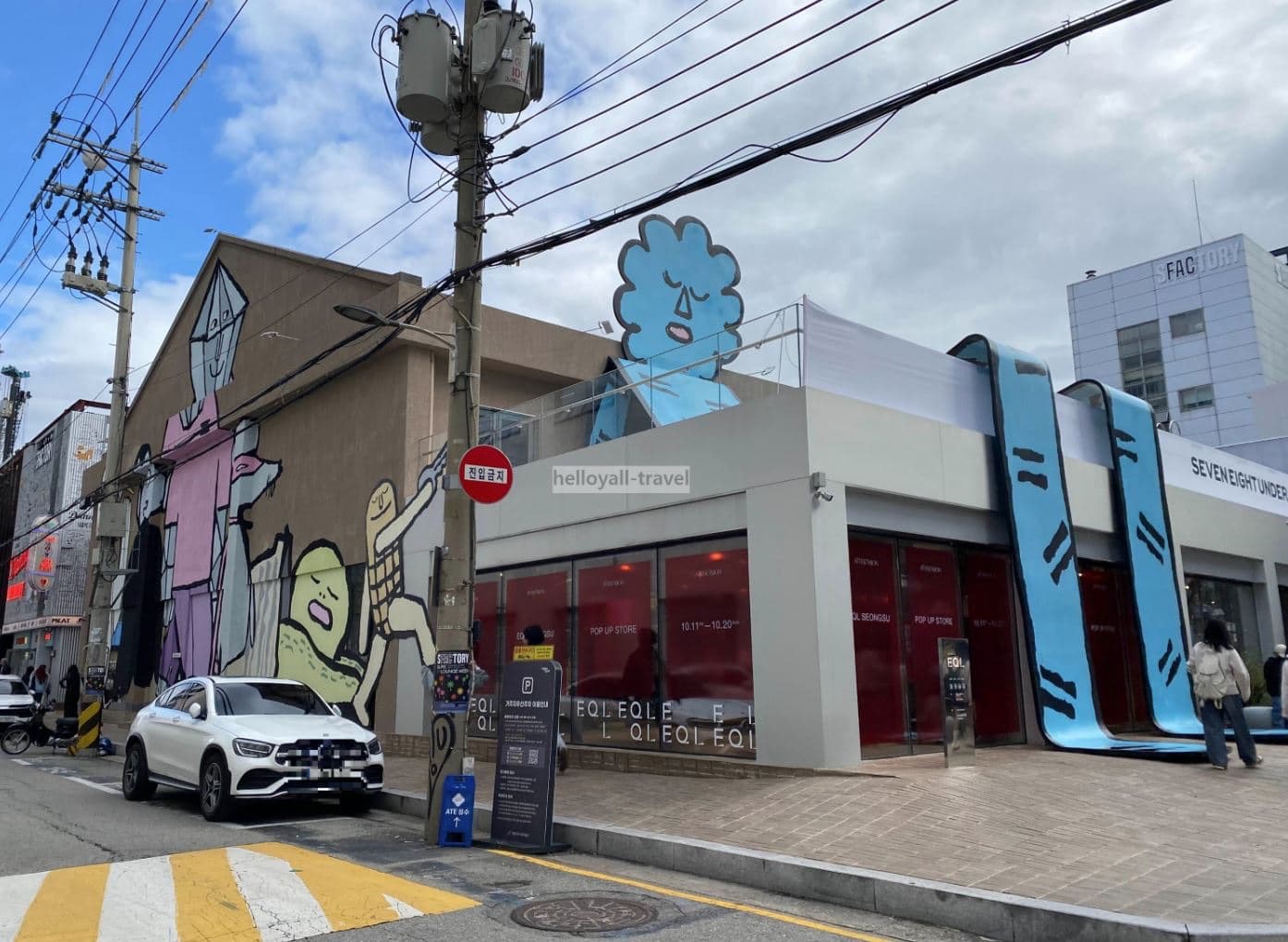 A Seongsu street corner with an EQL pop-up store and playful oversized cartoon murals painted across the building facade